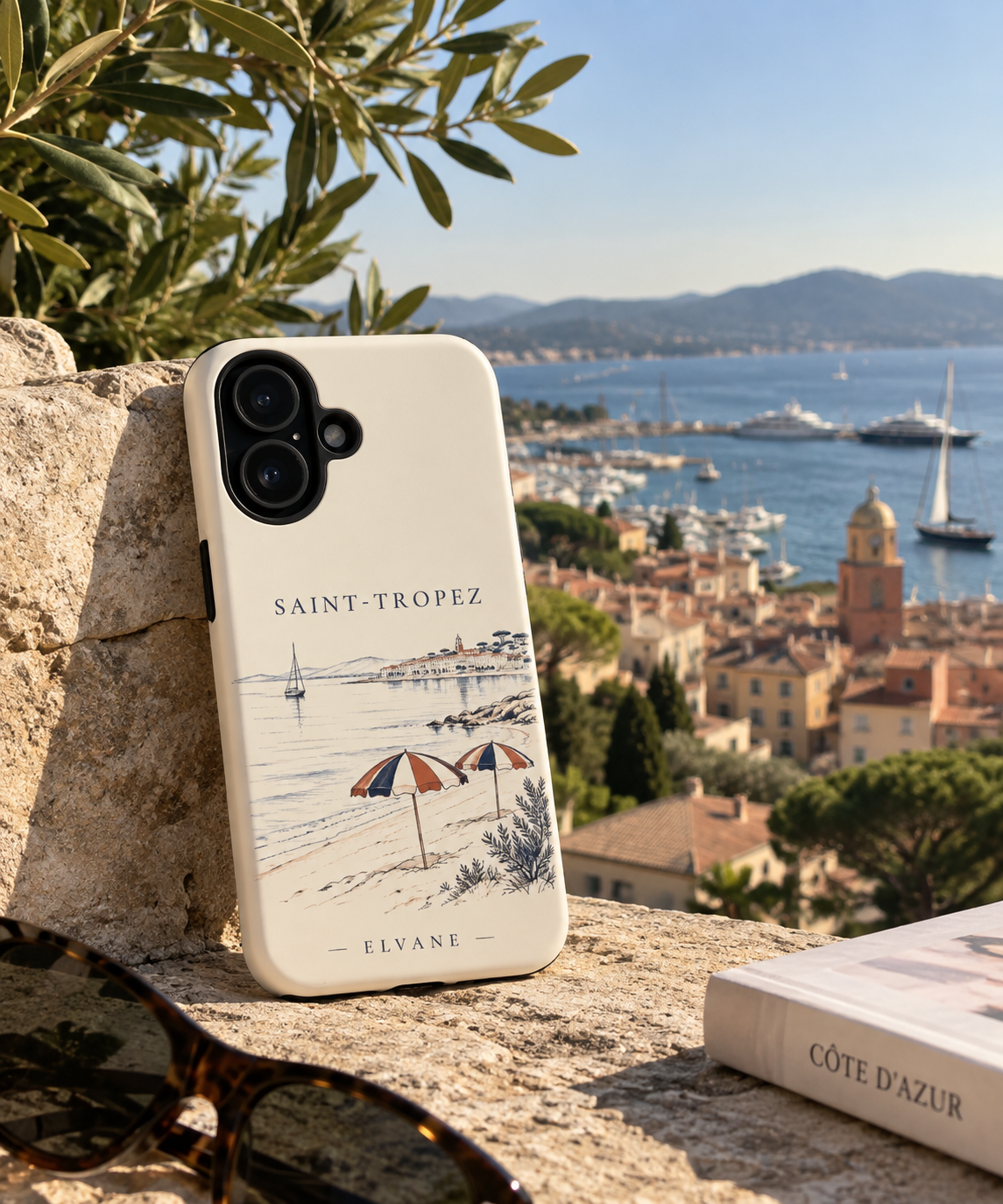 Coque Saint-Tropez ELVANE posée sur un muret de pierre, le port de Saint-Tropez en arrière-plan